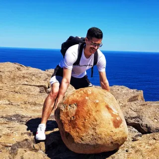 Treino ao ar livre: a empurrar uma rocha junto ao mar